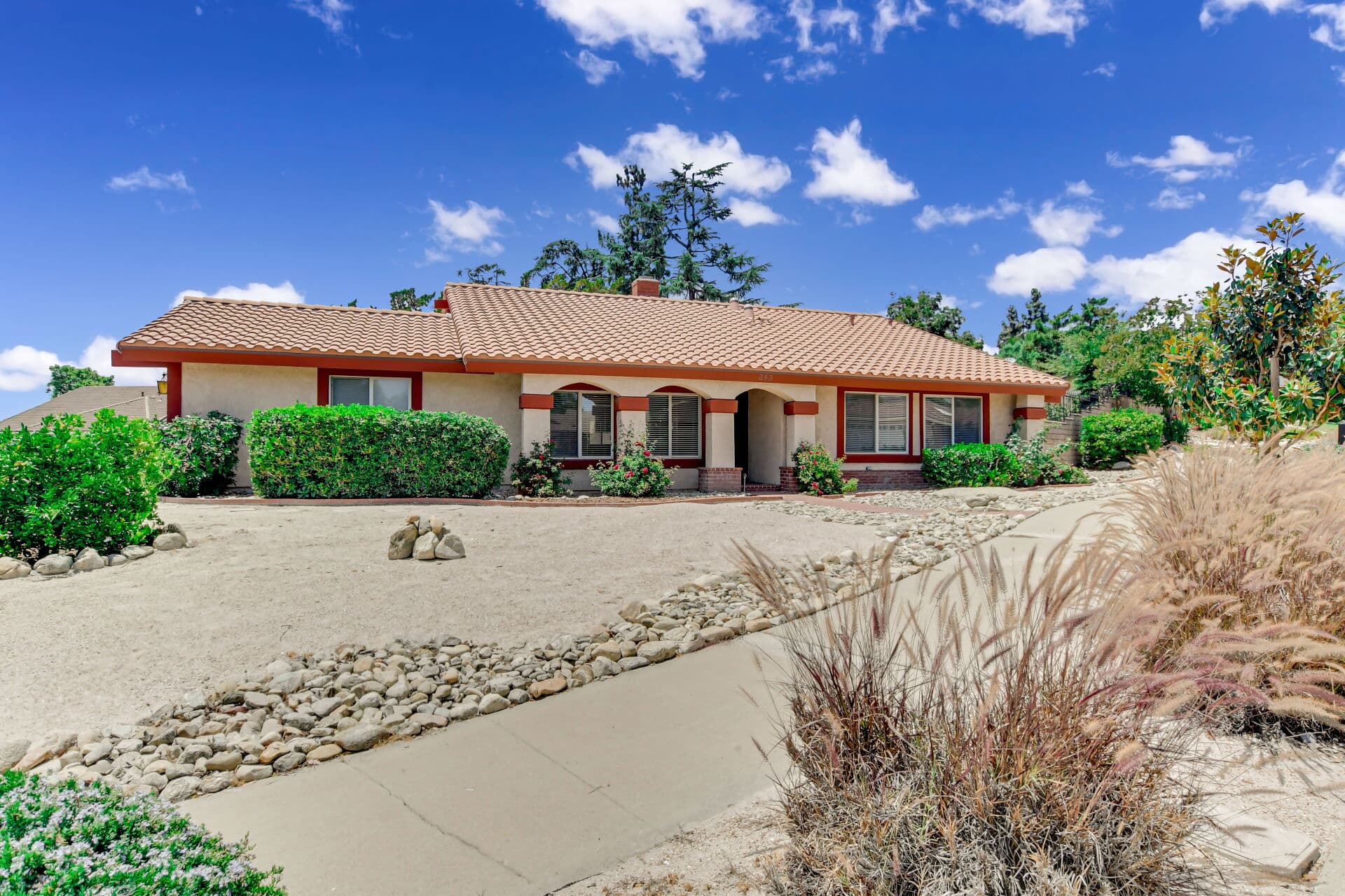 Spanish-style Claremont home with arched porch and xeriscaped front yard