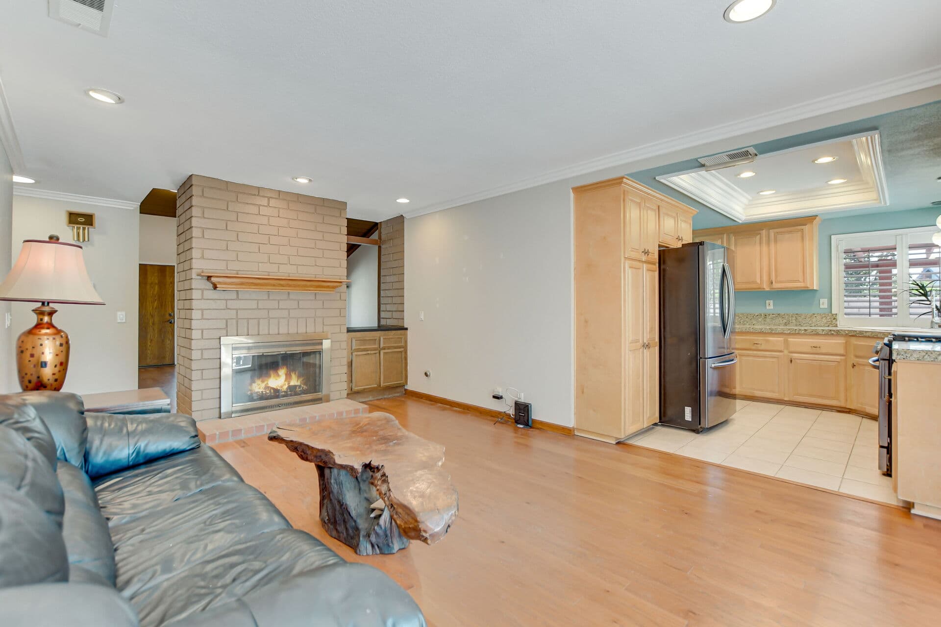 Claremont living room with a brick fireplace burning, one of the features California sellers must disclose details about