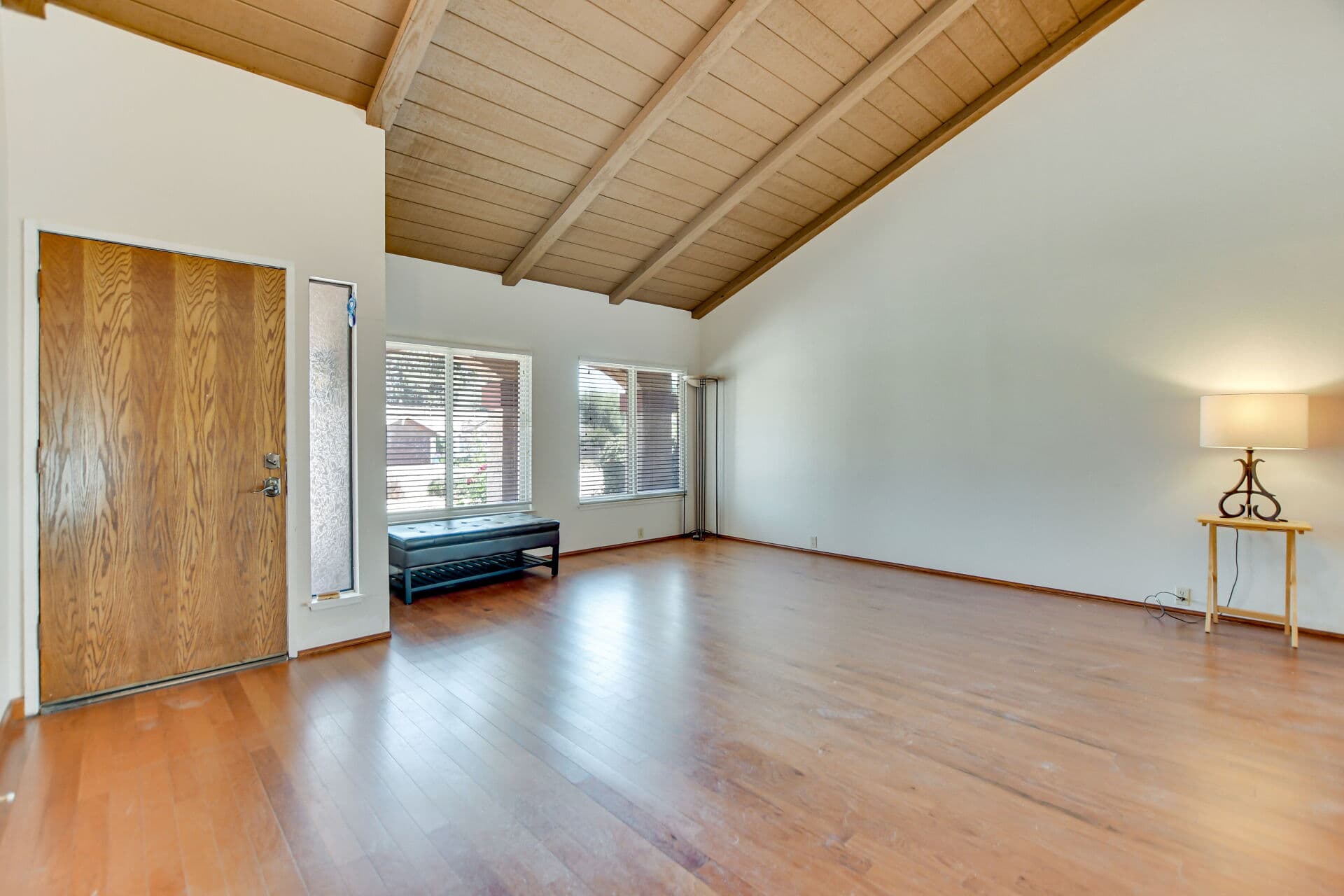Vacant lease-ready Claremont living room with bench by the front door