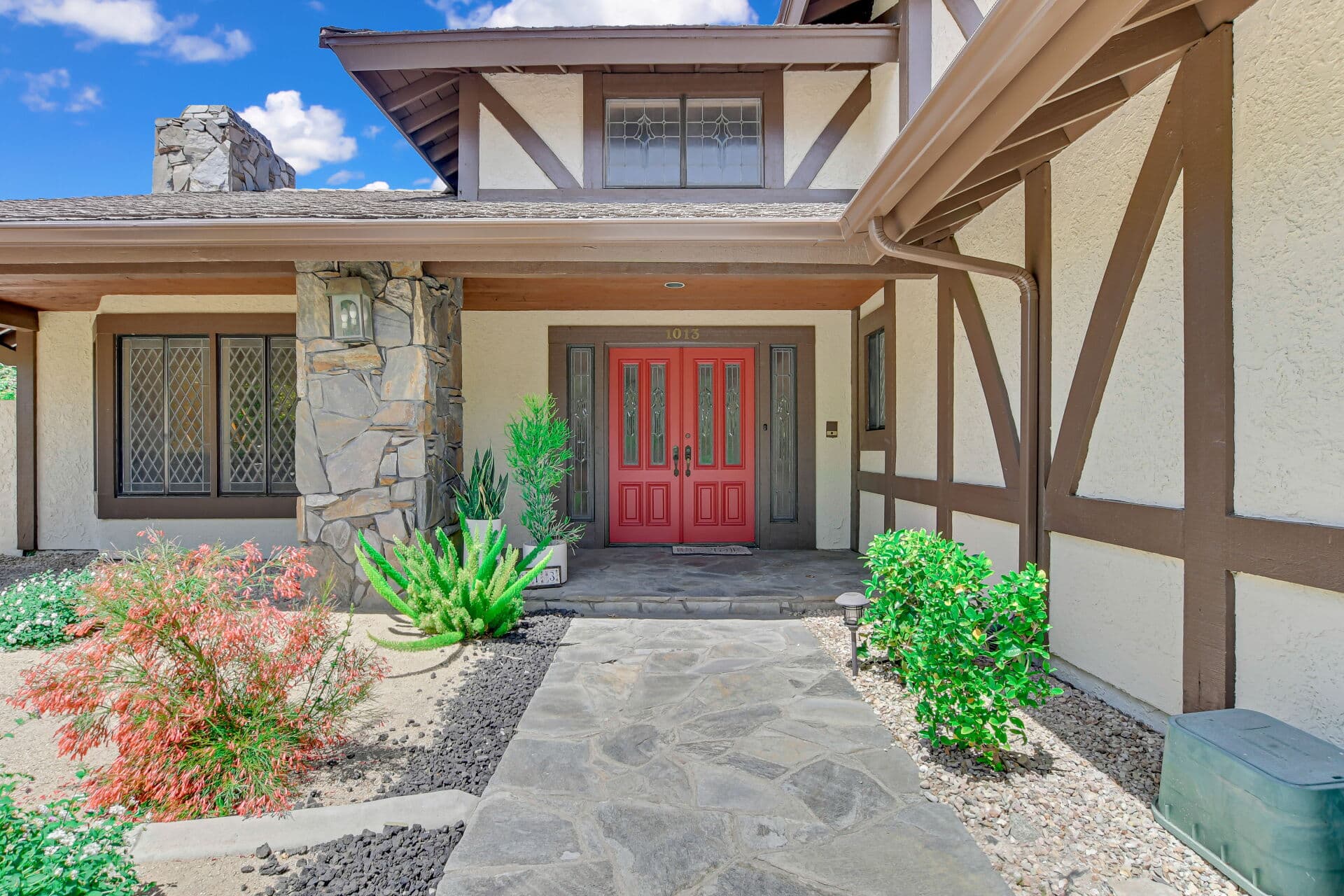Front entry with red double doors and stone column at a Claremont home