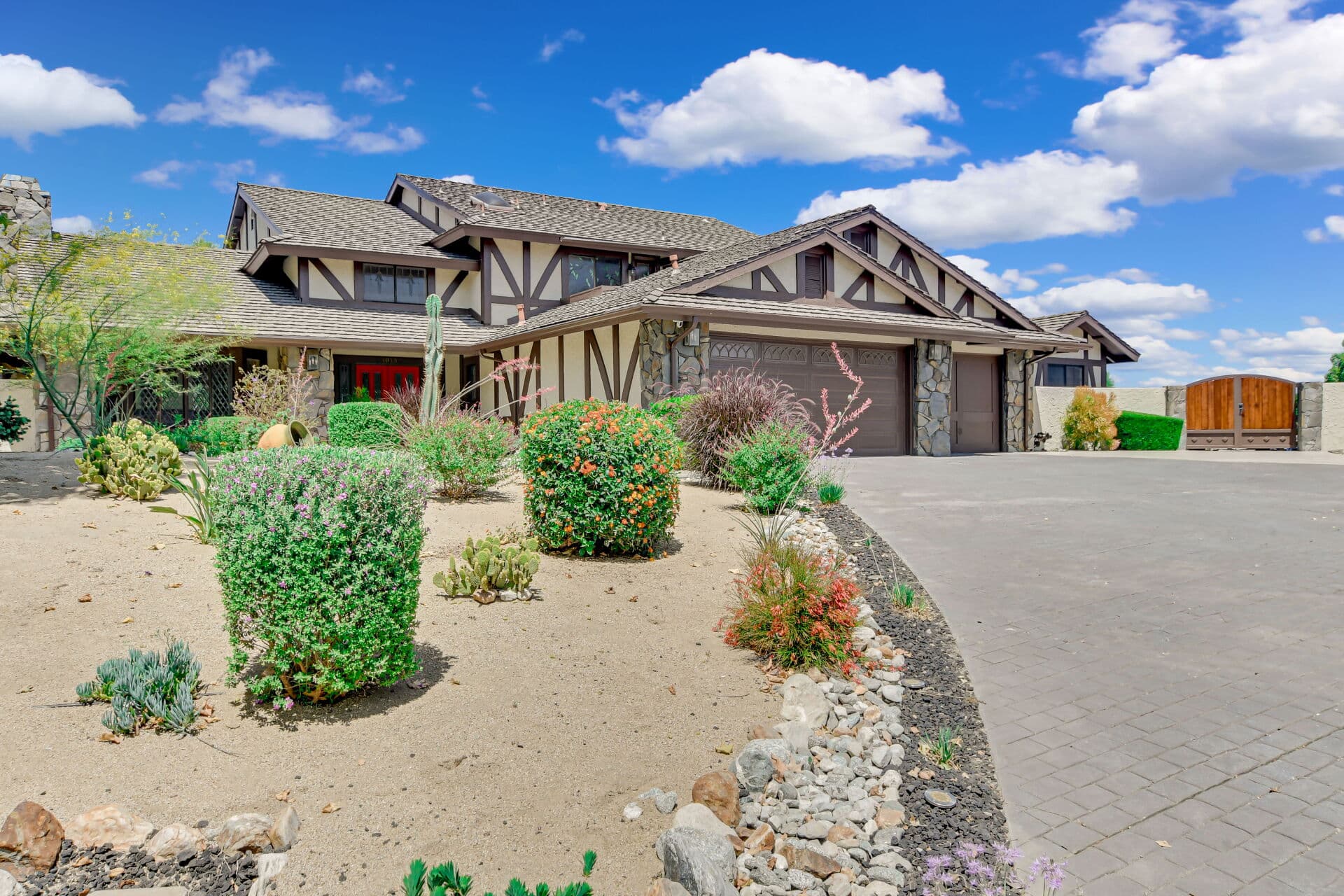 Front elevation of a Tudor-style Claremont home with paver drive