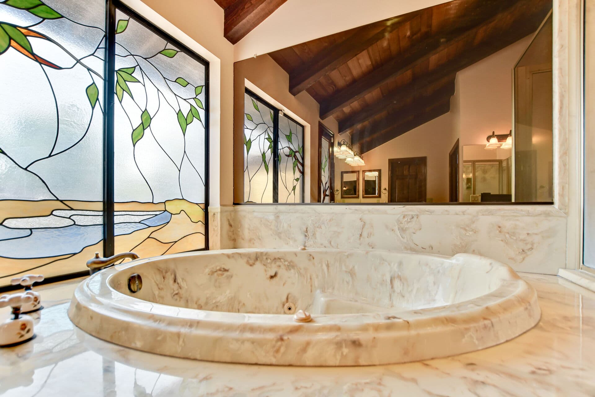 Bathroom with stained-glass windows above a tub in a Claremont home