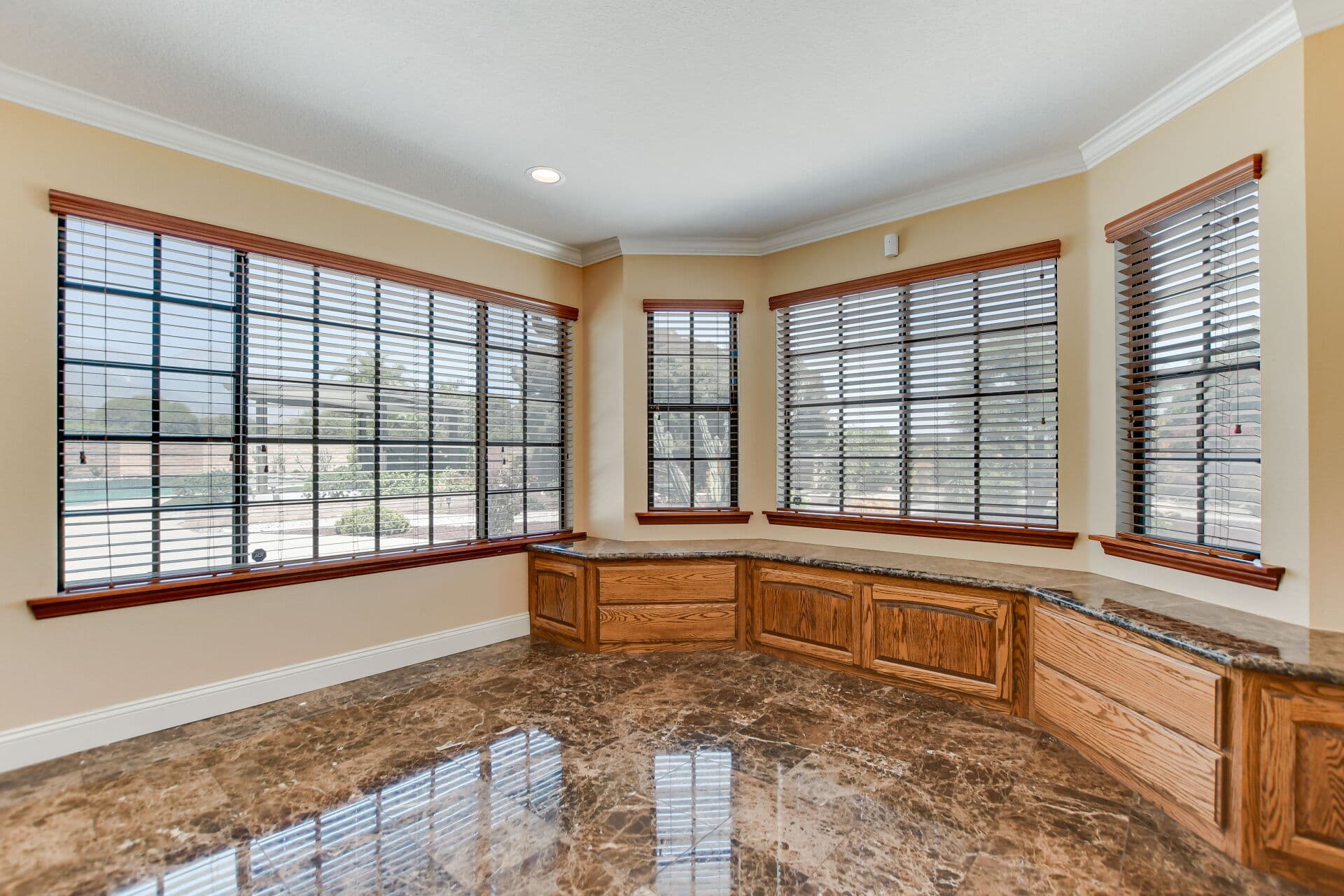 Empty sunroom with oak built-ins and a wall of windows in a Claremont home