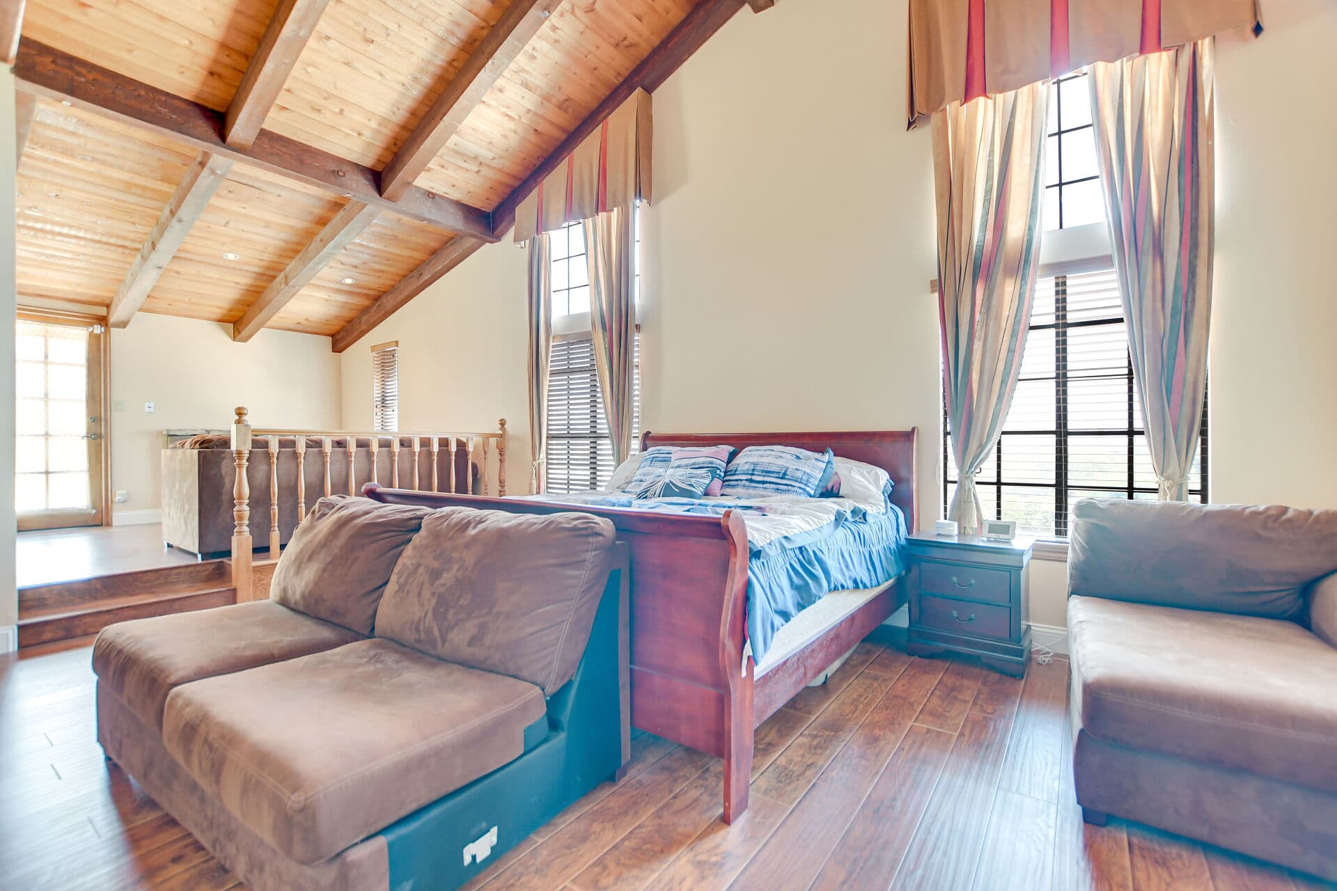 Loft bedroom with vaulted wood beams in a Claremont home