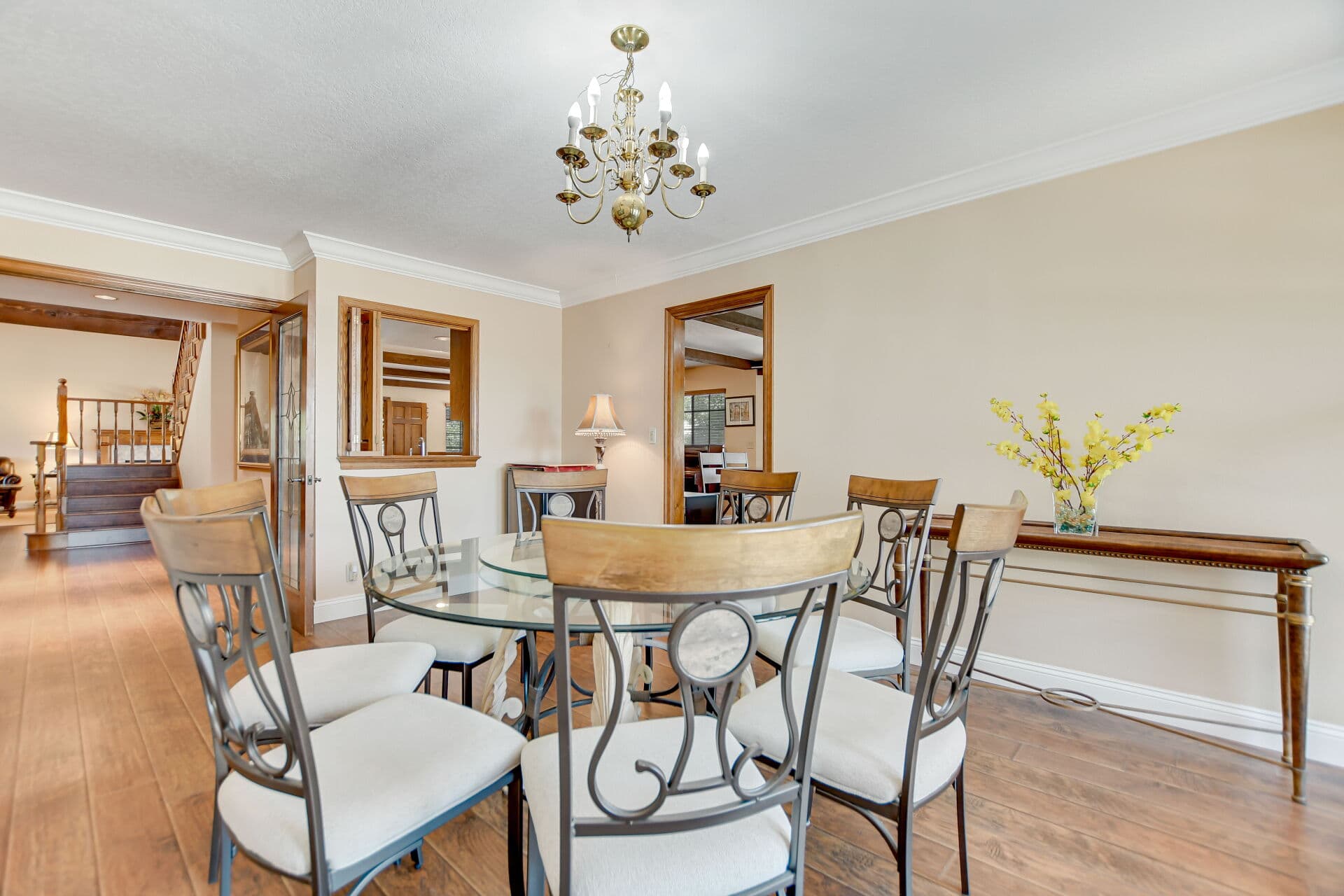Dining room with a glass table and brass chandelier in a Claremont home