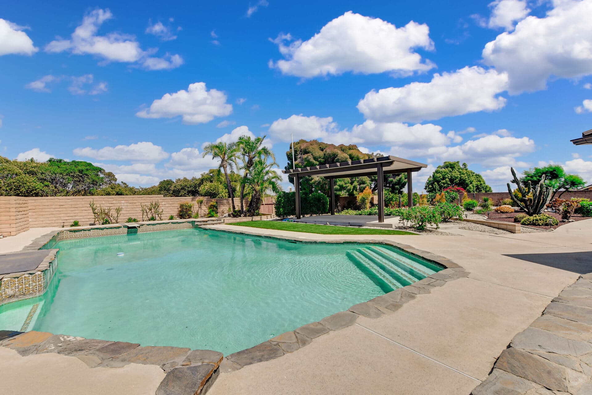 Backyard pool with a pergola and cactus garden at a Claremont home