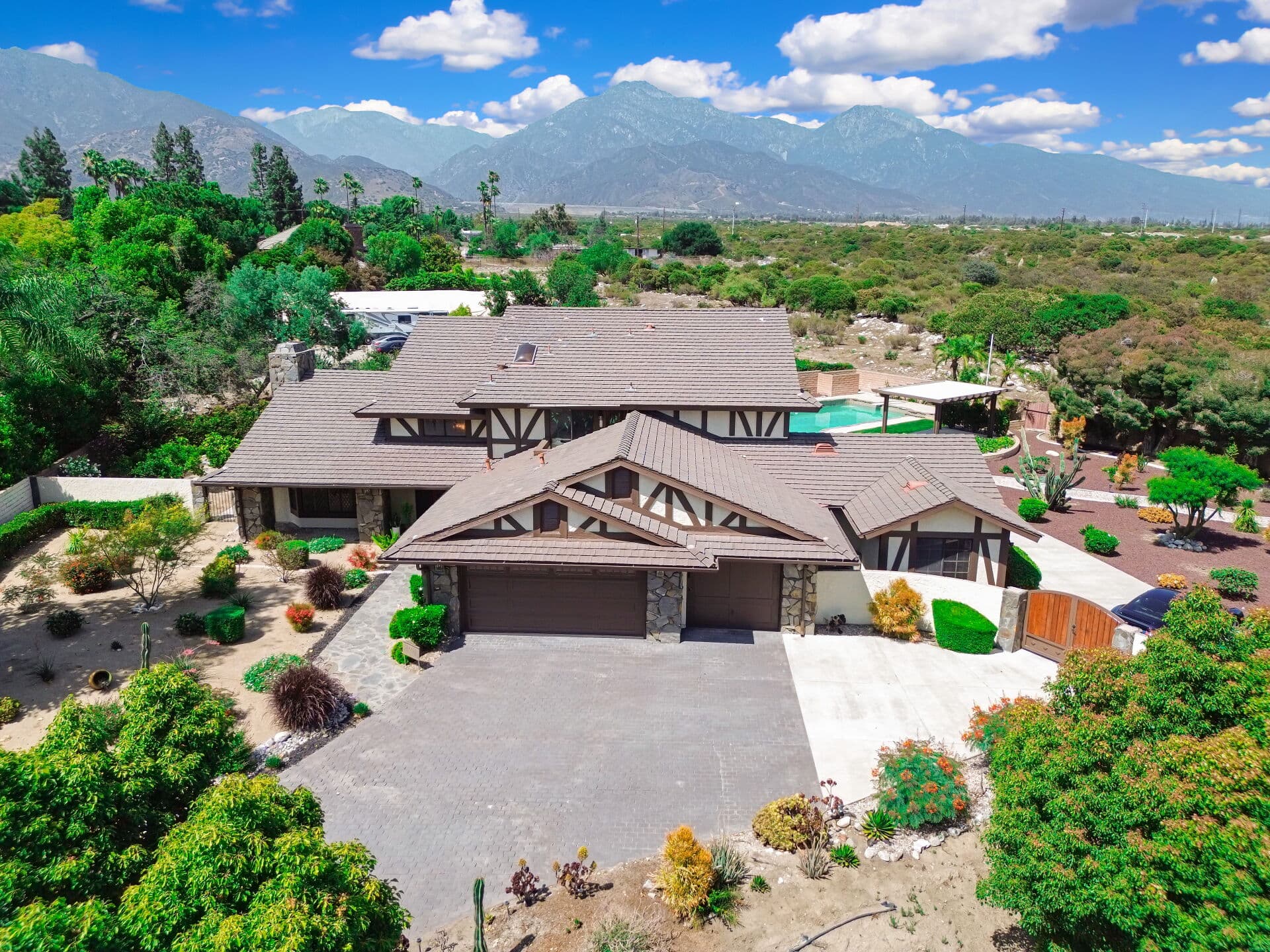 Aerial view of a Claremont home and pool with mountains beyond