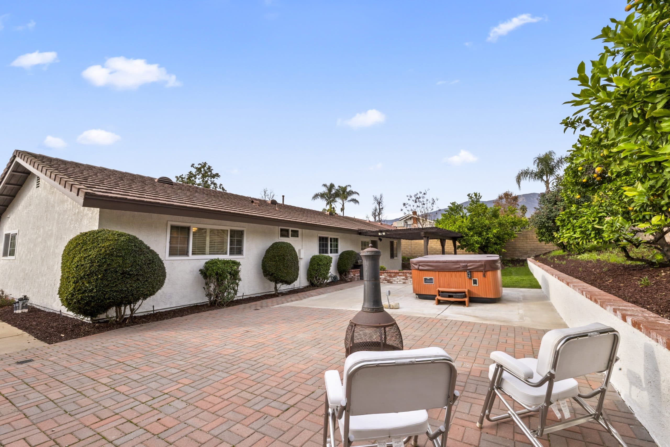 Wide rear view of a Claremont home with mountains rising behind the roofline