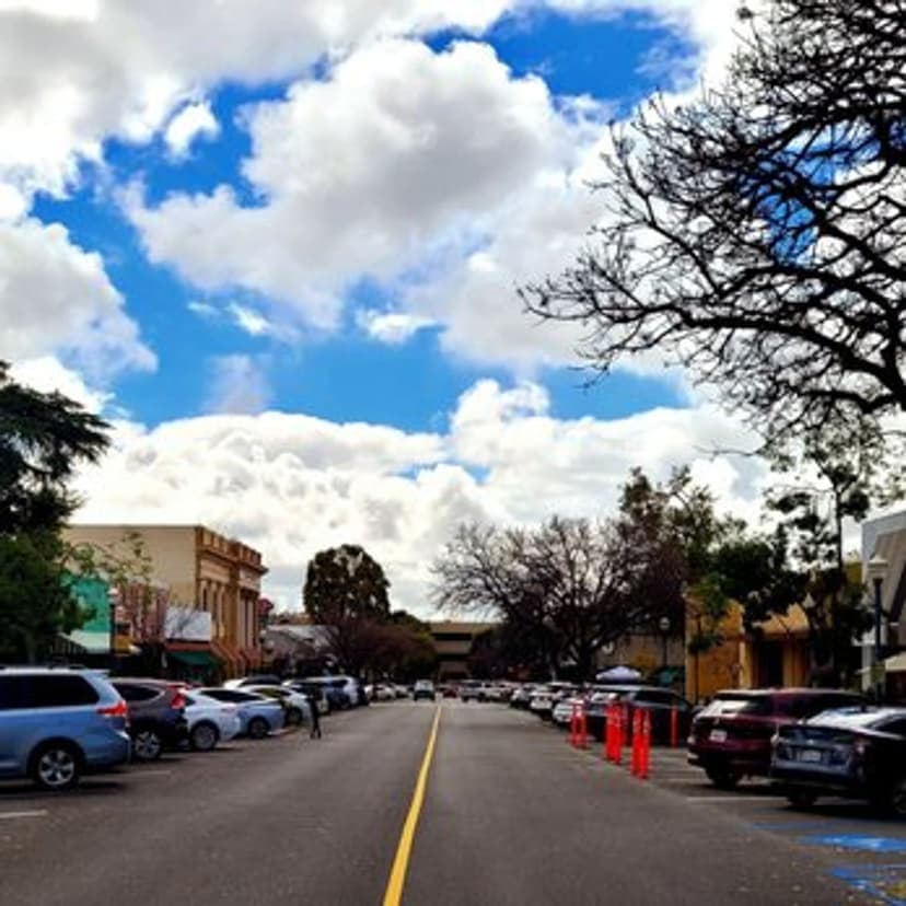 Storefronts along a tree-lined street in the Claremont Village
