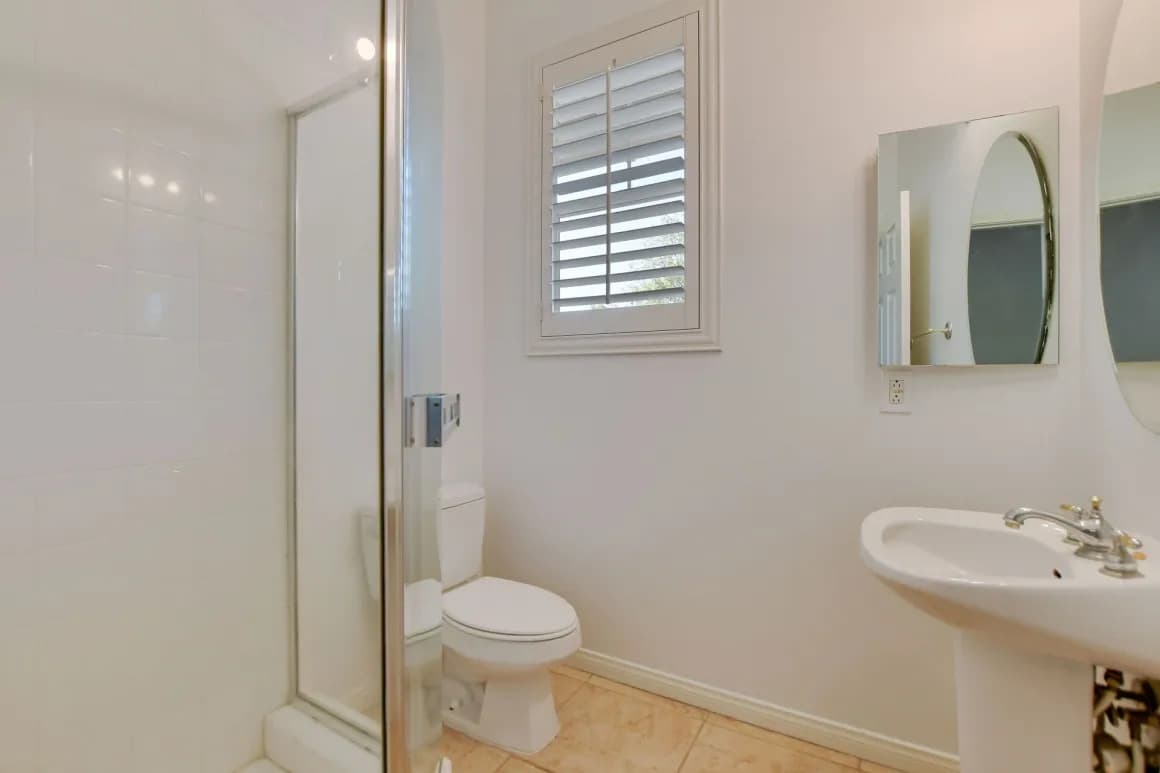 Bathroom with walk-in shower and pedestal sink in a Claremont home