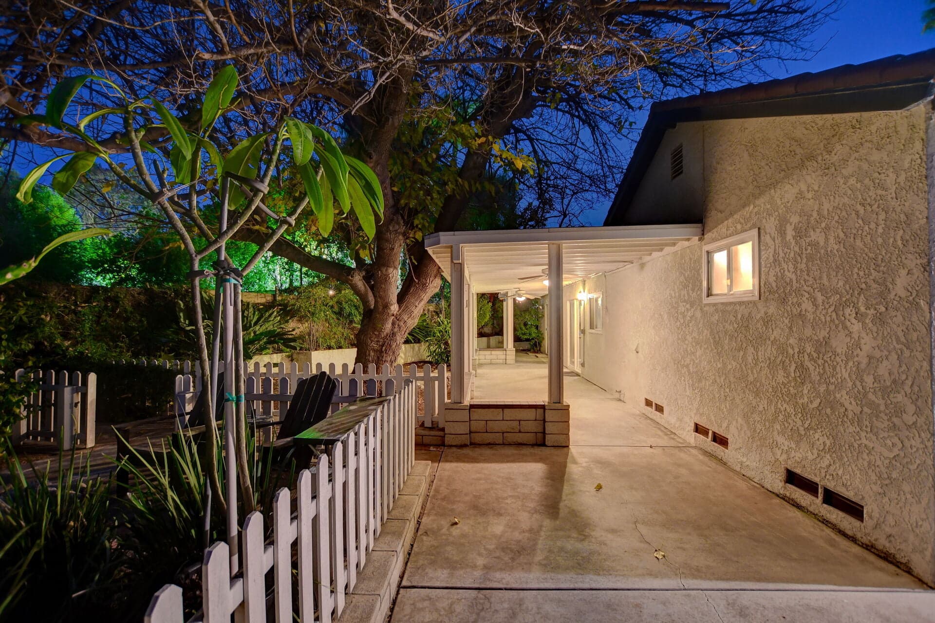 Covered backyard patio structure at dusk behind a Claremont home