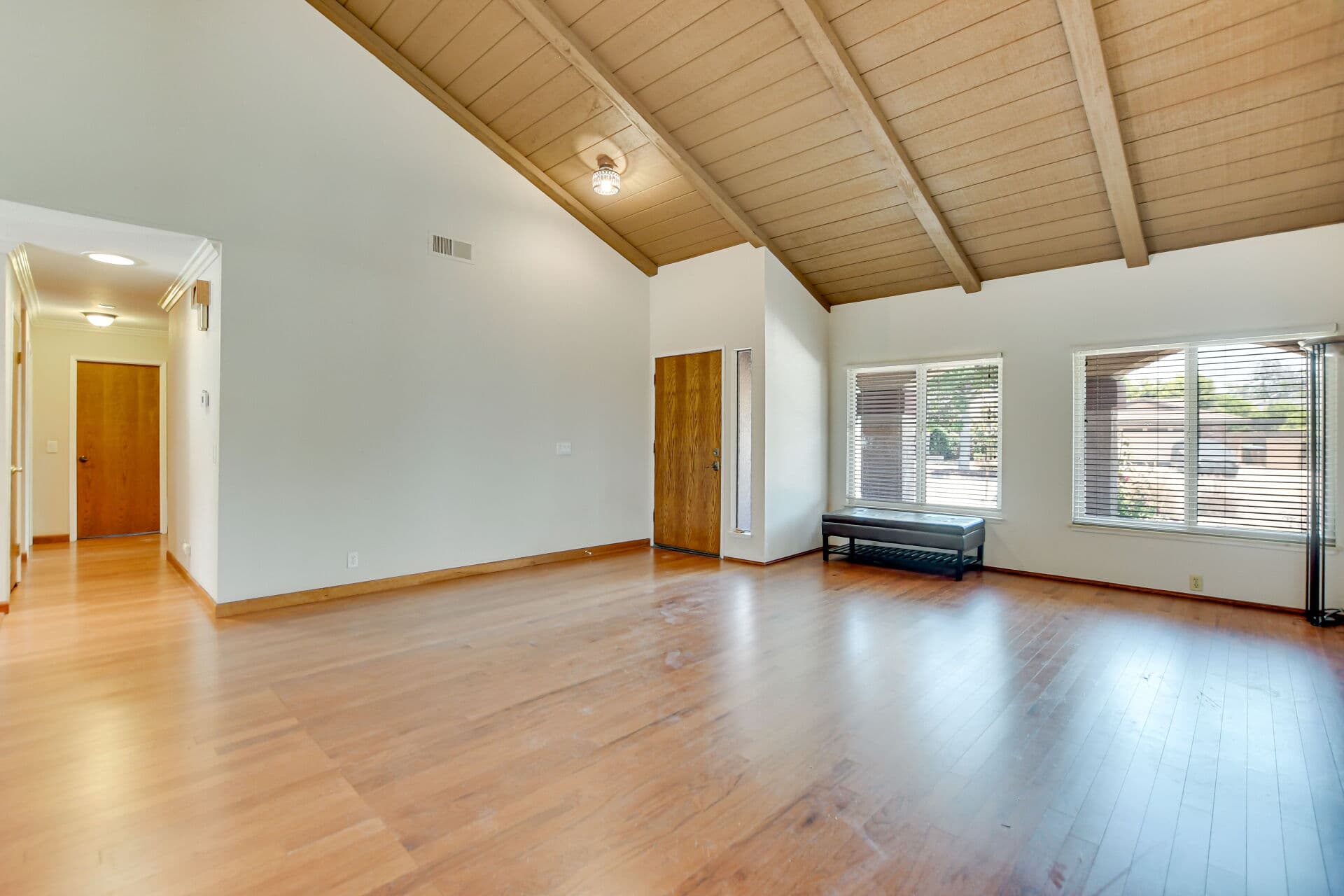 Unfurnished vaulted living room by the front door of a Claremont home, ready for a renter to move in