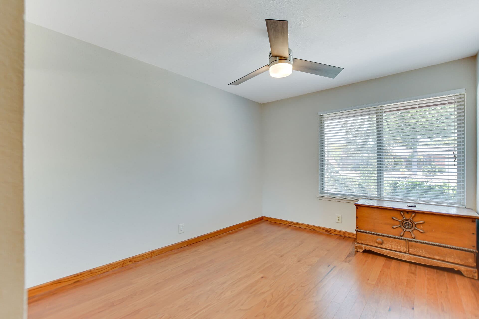 Vacant Claremont bedroom with a wooden chest beneath the window