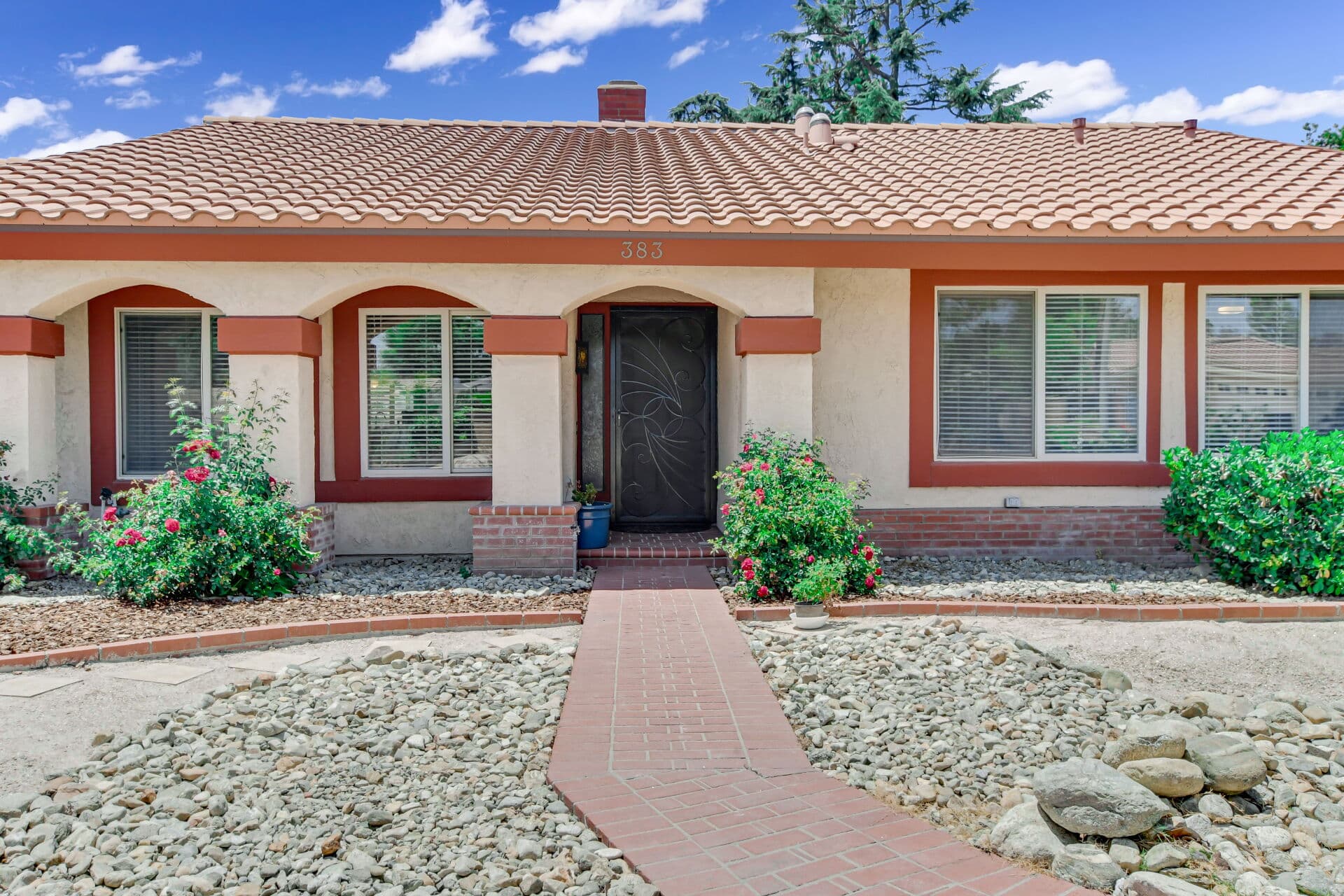 Front entry of an older Spanish-style Claremont ranch with a tile roof and arches