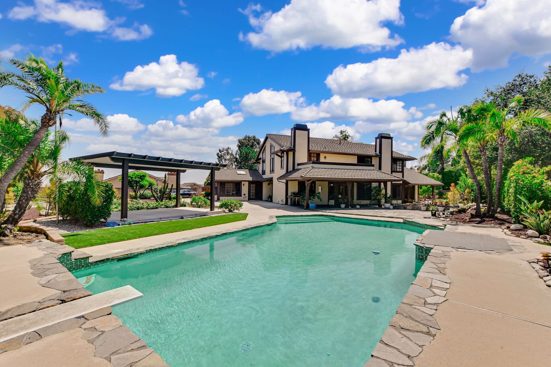 Backyard pool with diving board and palms at a Claremont home