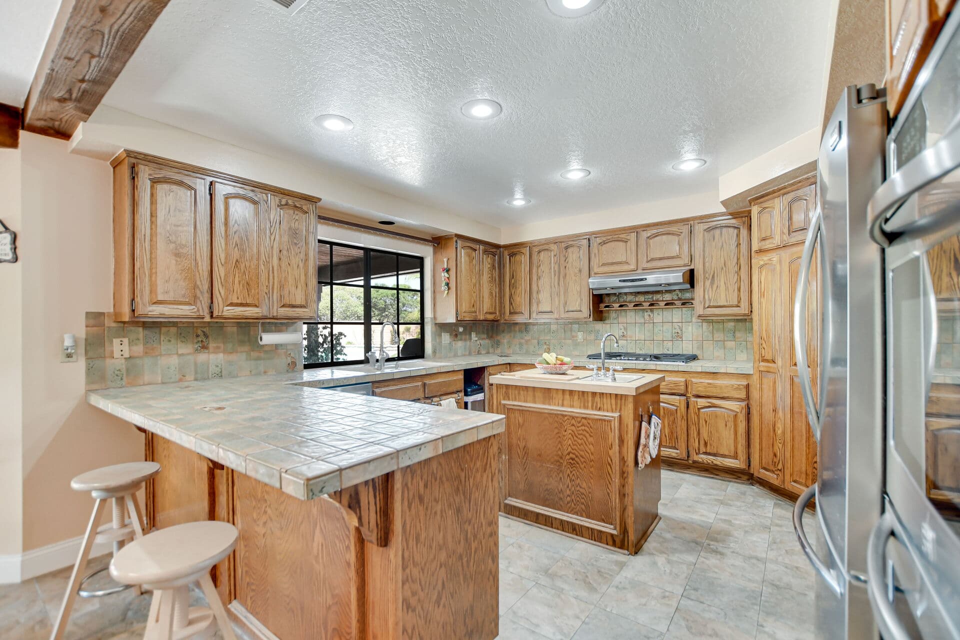 Kitchen with oak cabinets, tile counters, and an island in a Claremont home