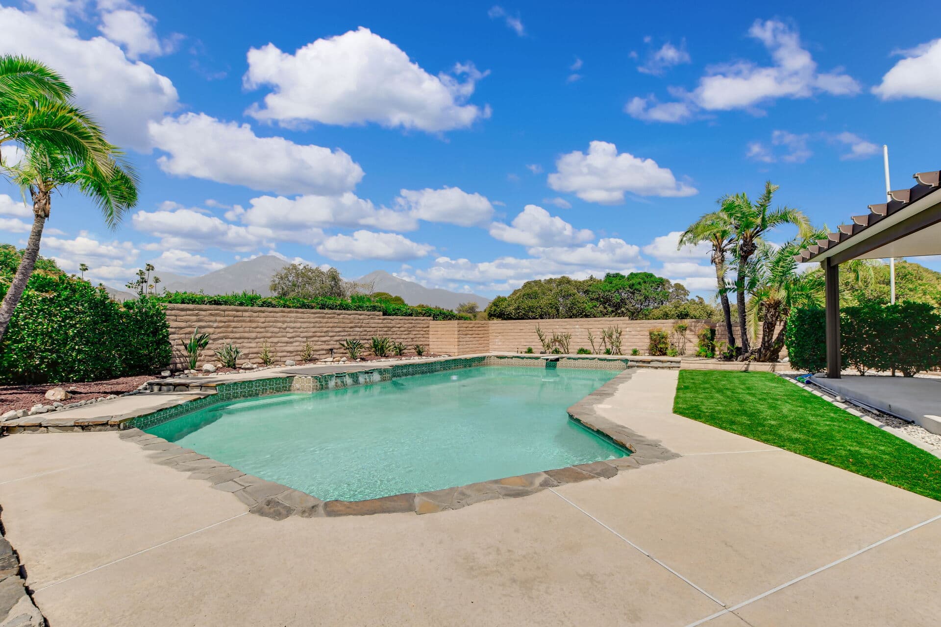 Mature Claremont backyard with a pool, palms, and the San Gabriel Mountains behind