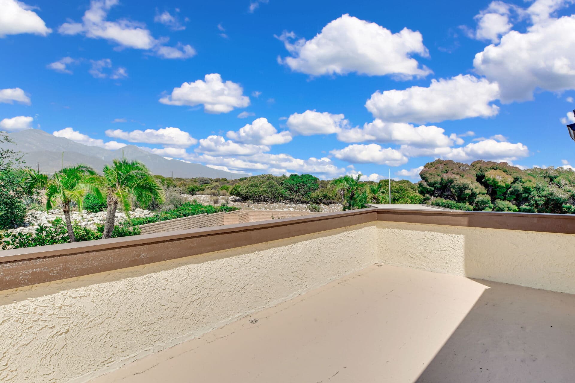 Balcony view over a rock wash toward the San Gabriel Mountains in Claremont