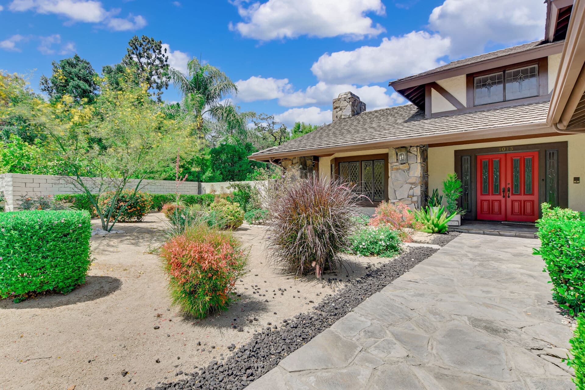 Front entry of a Claremont home with a red double door and stone columns