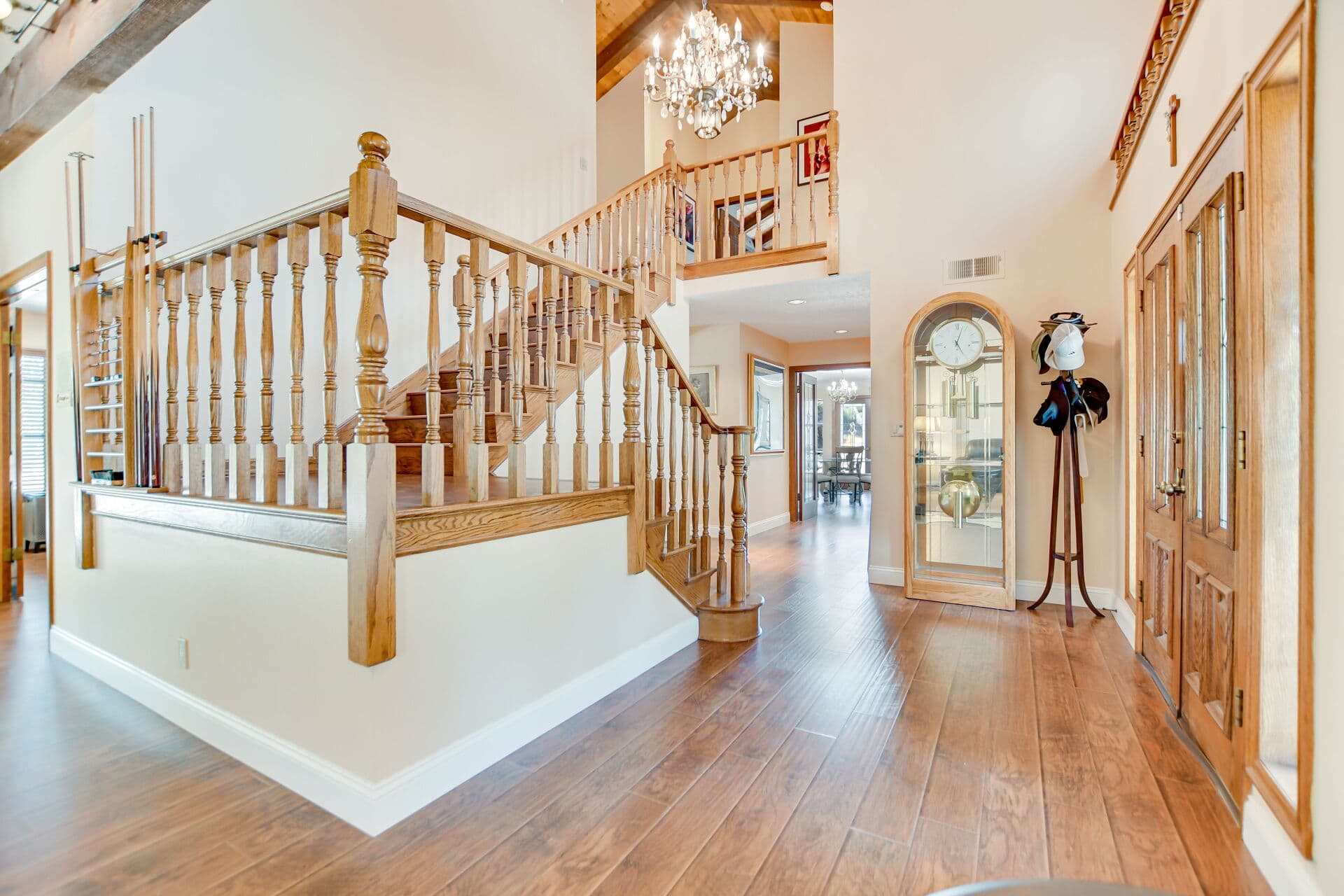 Foyer staircase with turned-oak balustrade and chandelier in a Claremont home