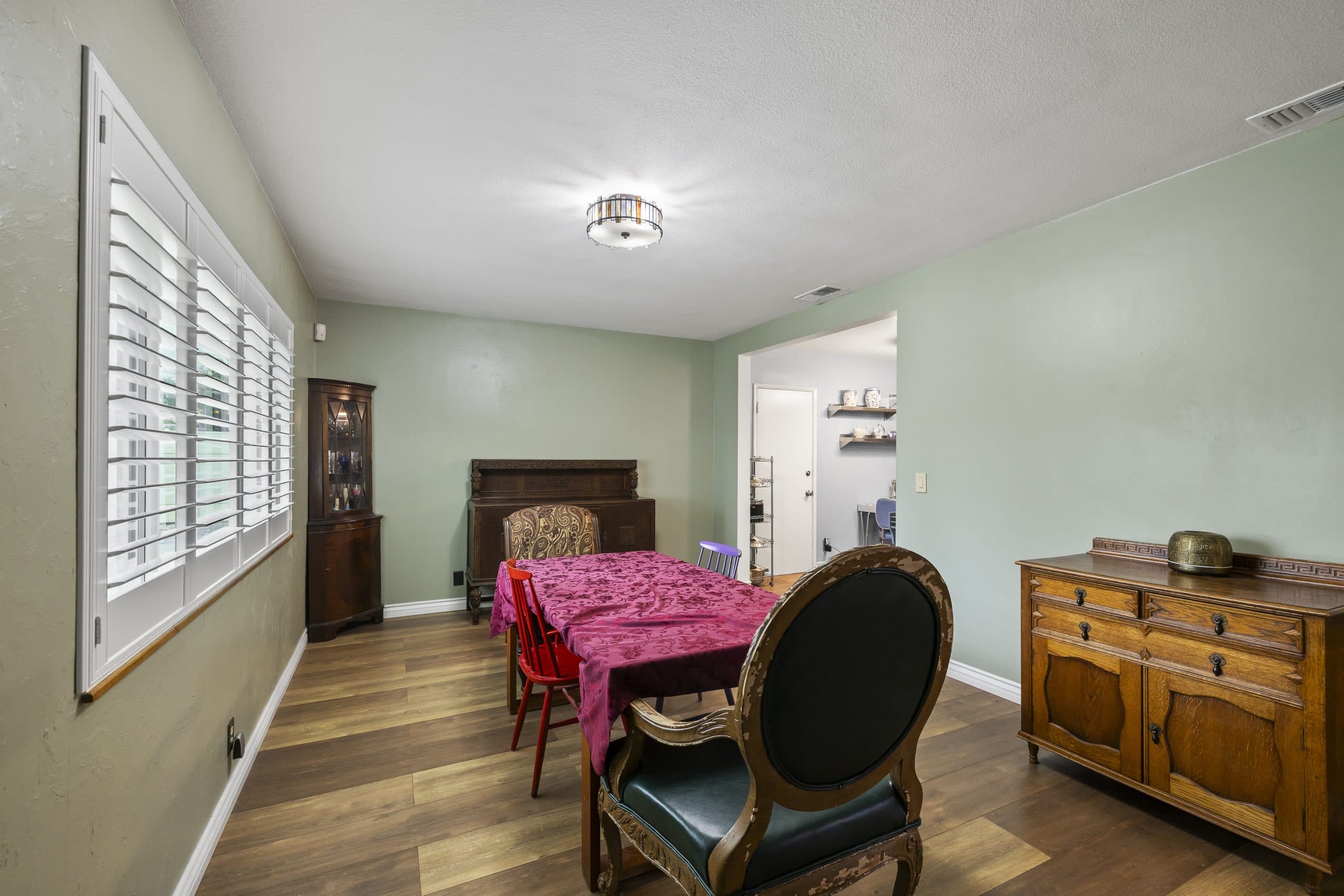 Dining room table beside a shuttered window in a Claremont home