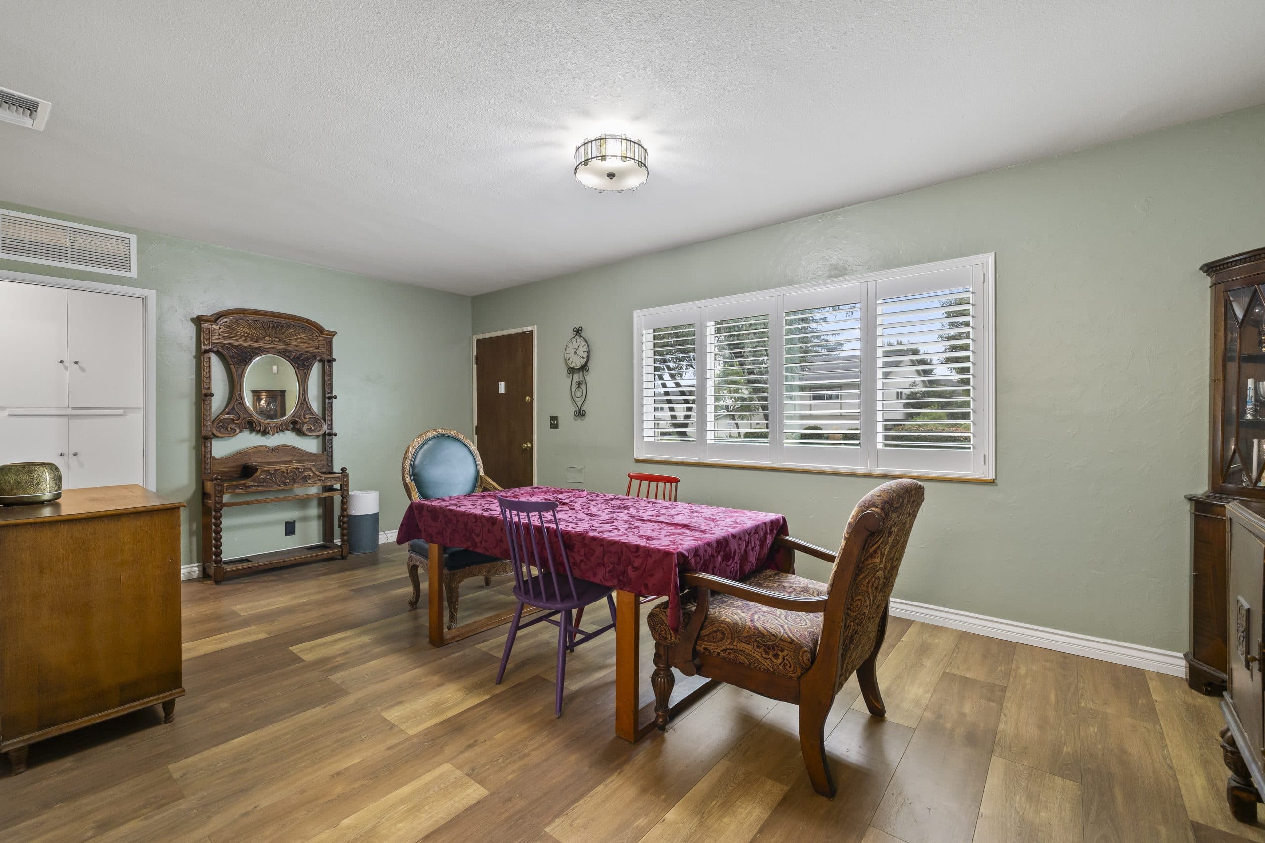 Lived-in Claremont dining room with a neighboring home visible through shutters
