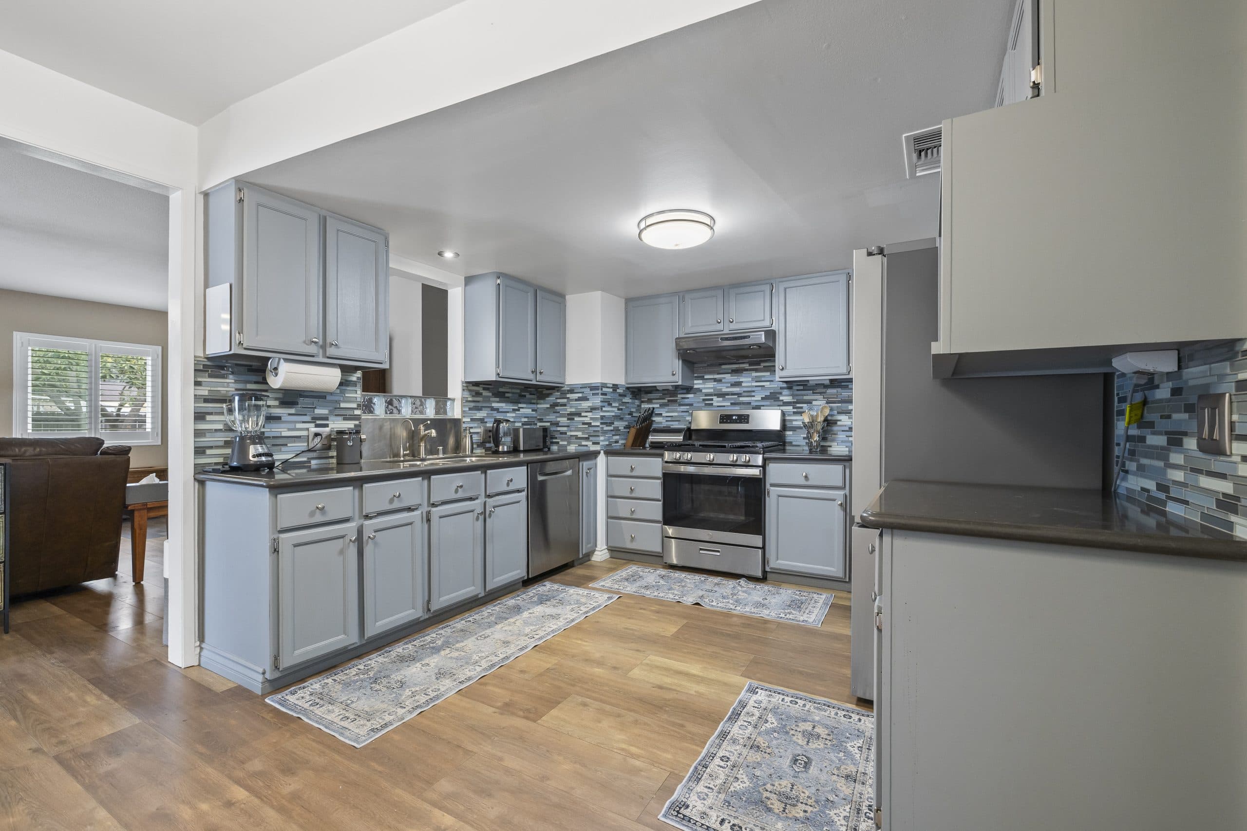 Remodeled kitchen with blue-grey cabinets and tile backsplash in a Claremont home