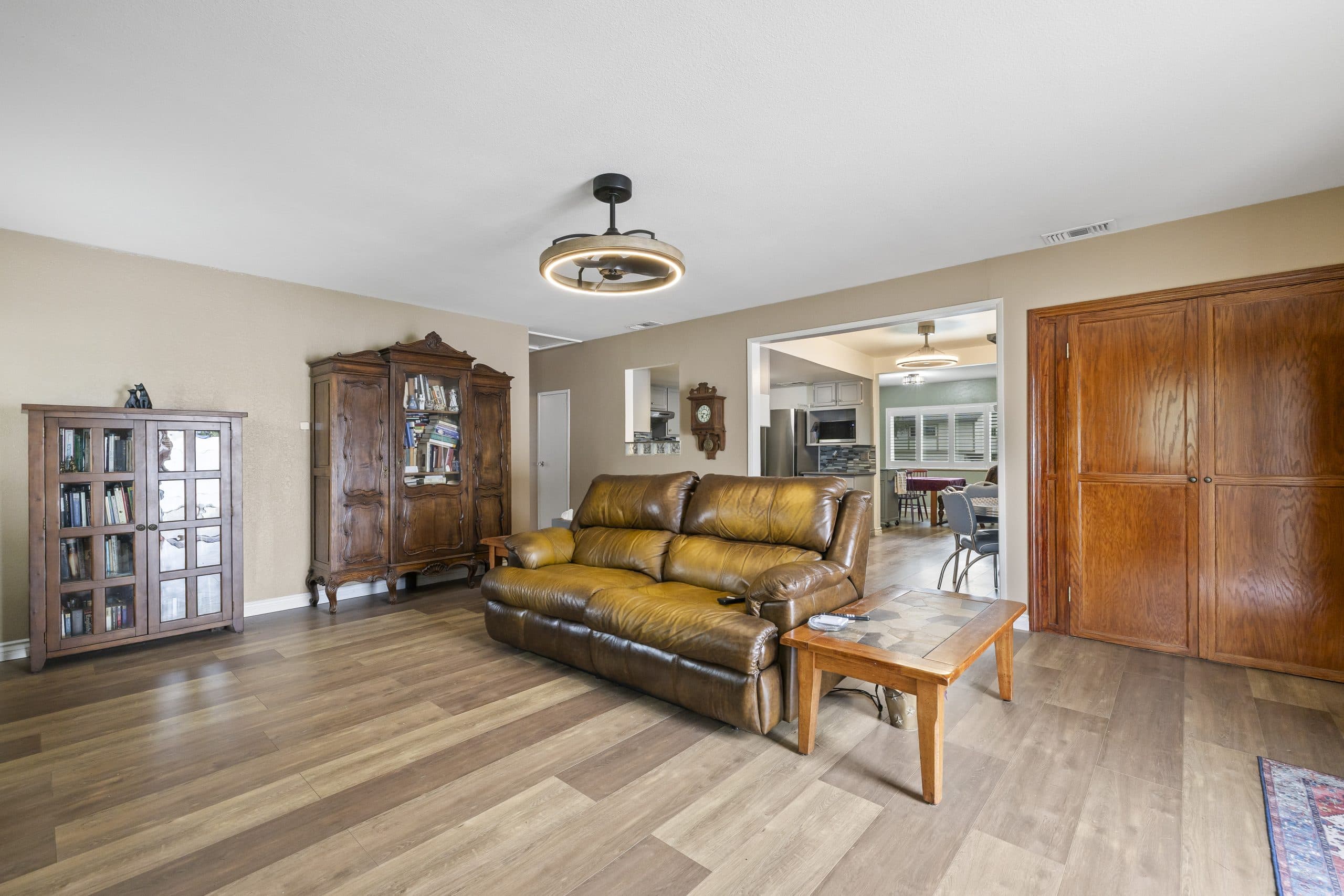 Sitting room of a Claremont home with a leather sofa and antique wood bookcases