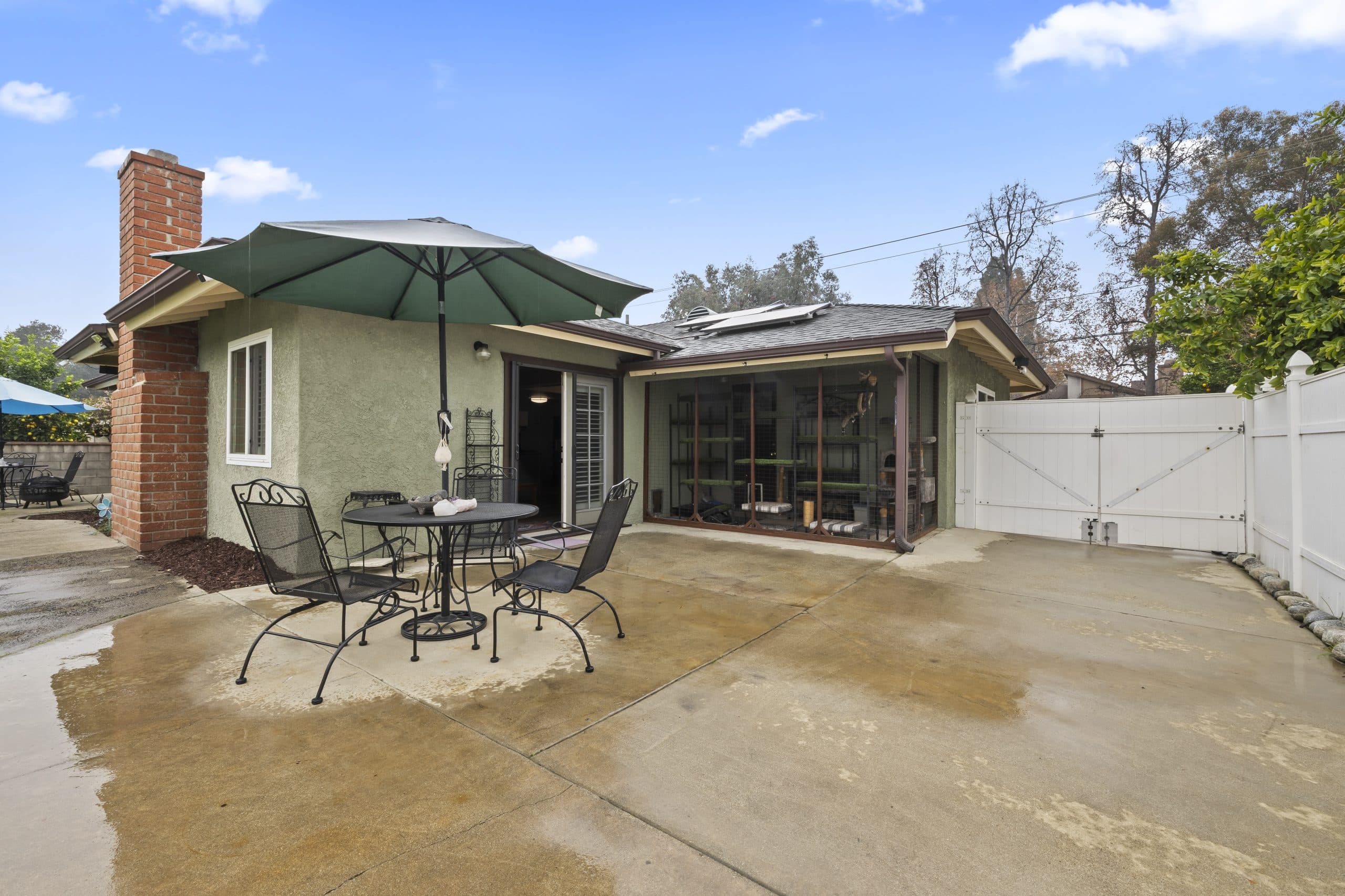 Rear exterior and patio of a Claremont home with a screened porch