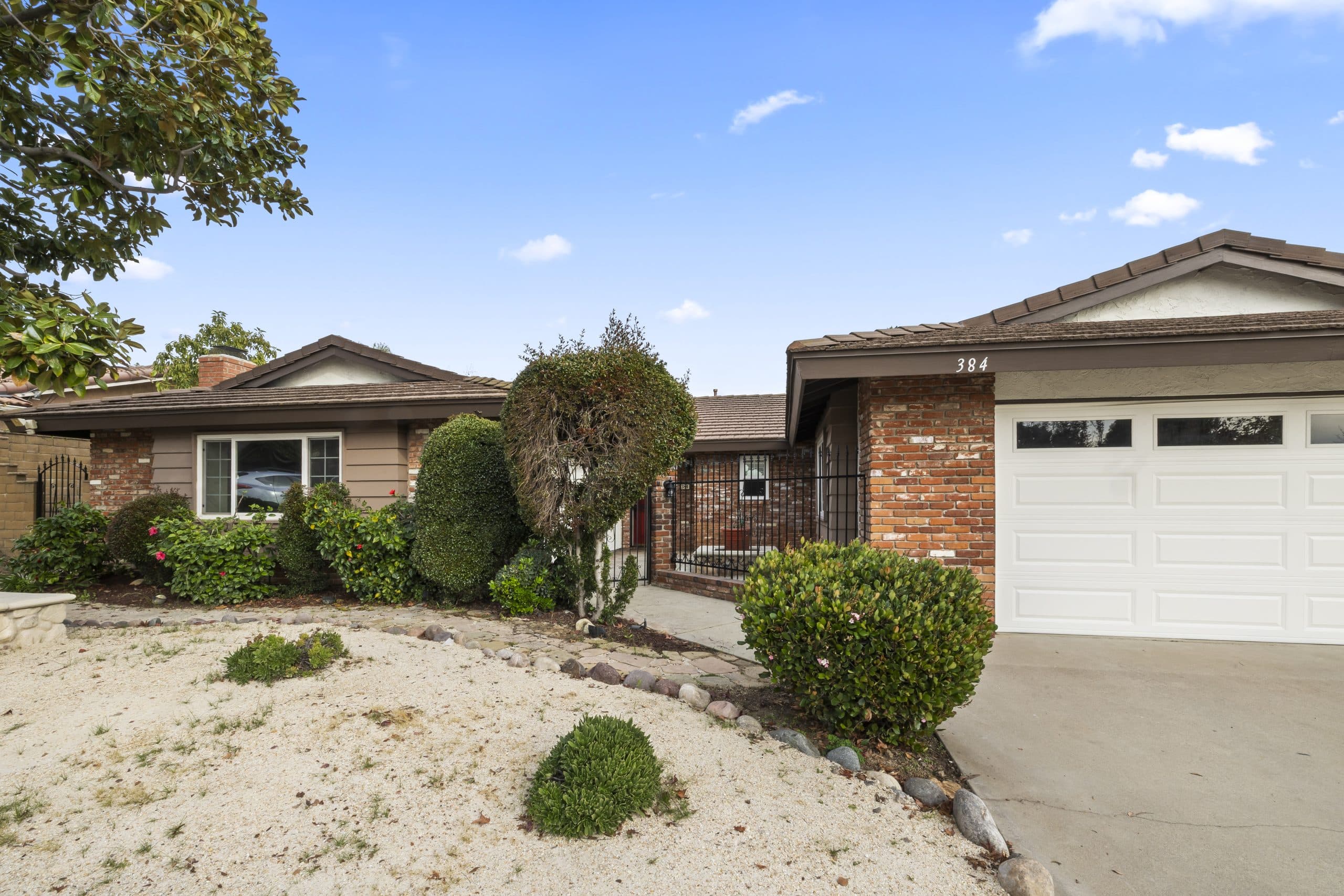 Used-brick frontage and wrought-iron gate showing a Claremont home's era details