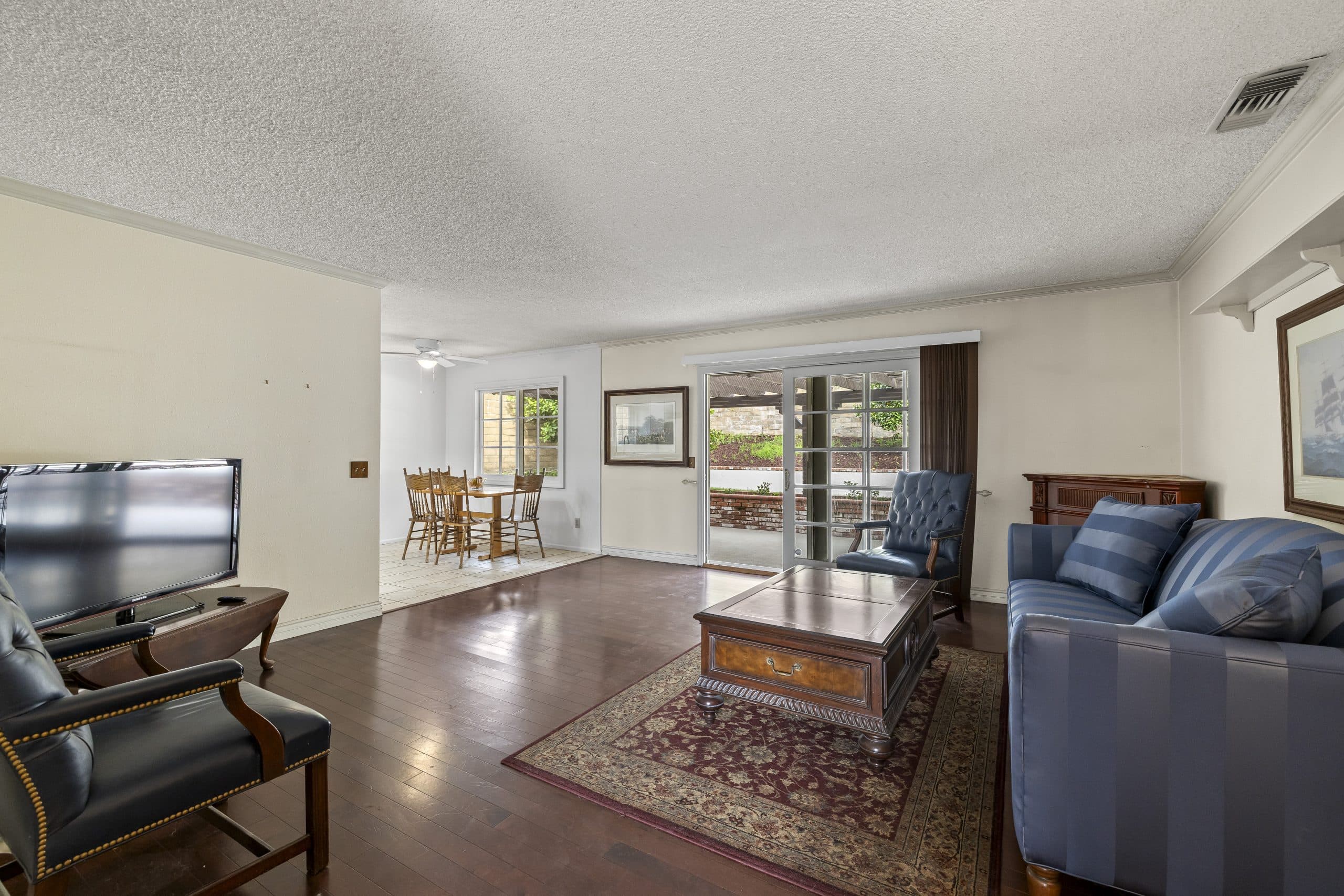 Calm traditional Claremont living room with leather chairs and oriental rug