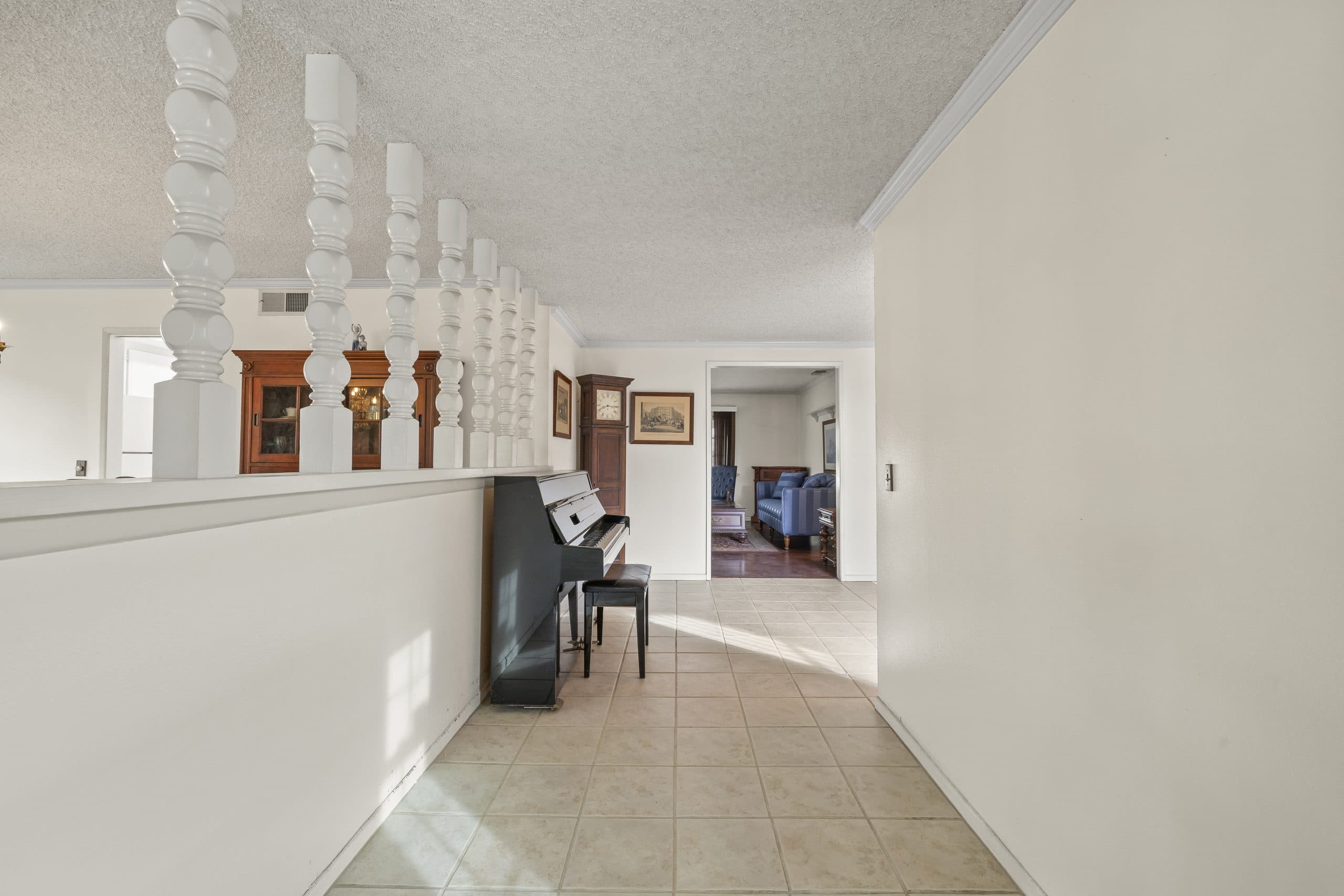 Formal entry hall of a Claremont home with a piano and grandfather clock