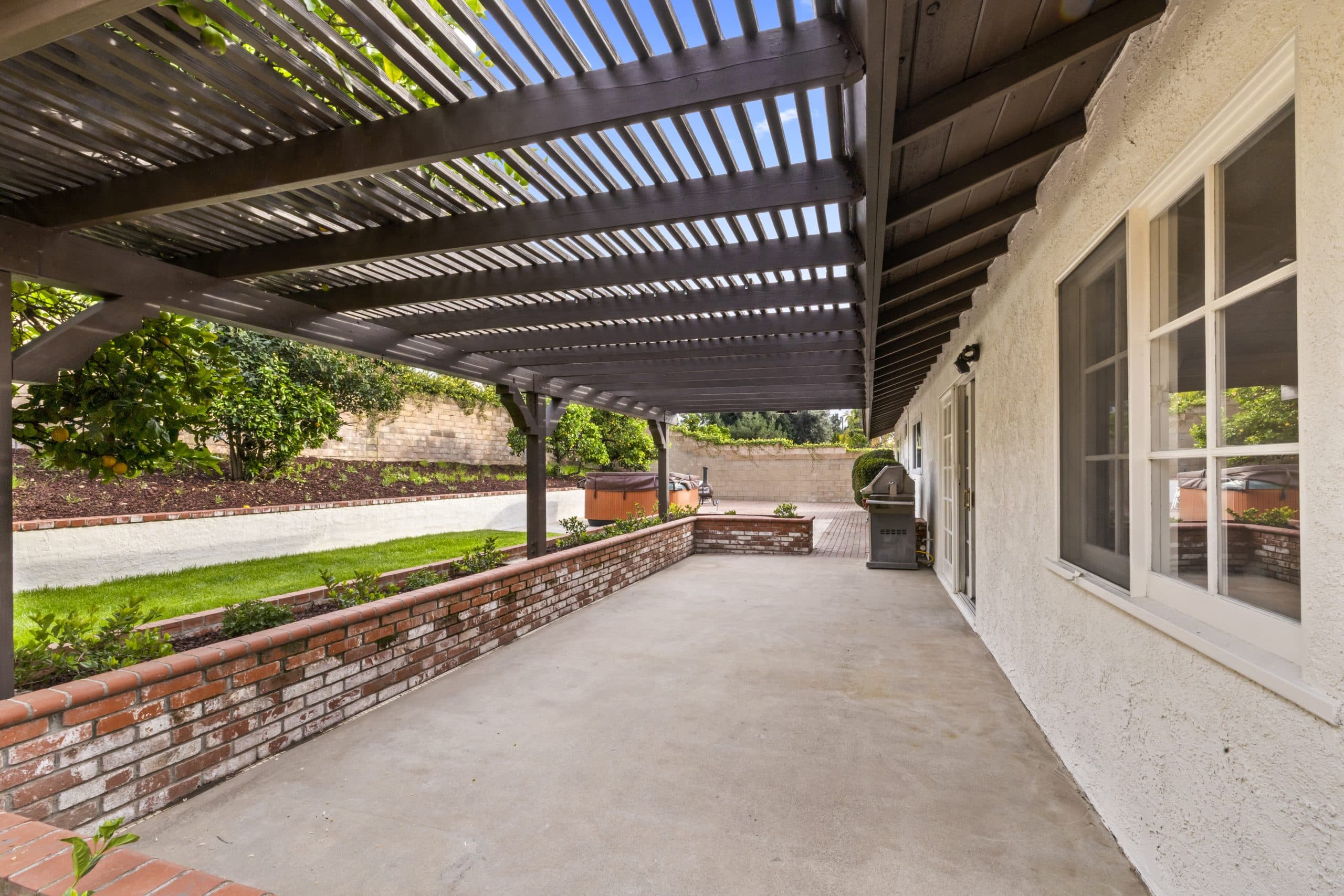 Covered pergola garden patio with mature plantings at a Claremont home
