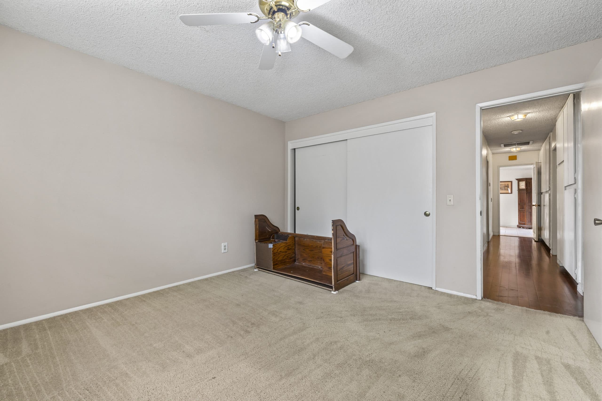 Vacant bedroom mid-move with furniture pieces on the floor in a Claremont home