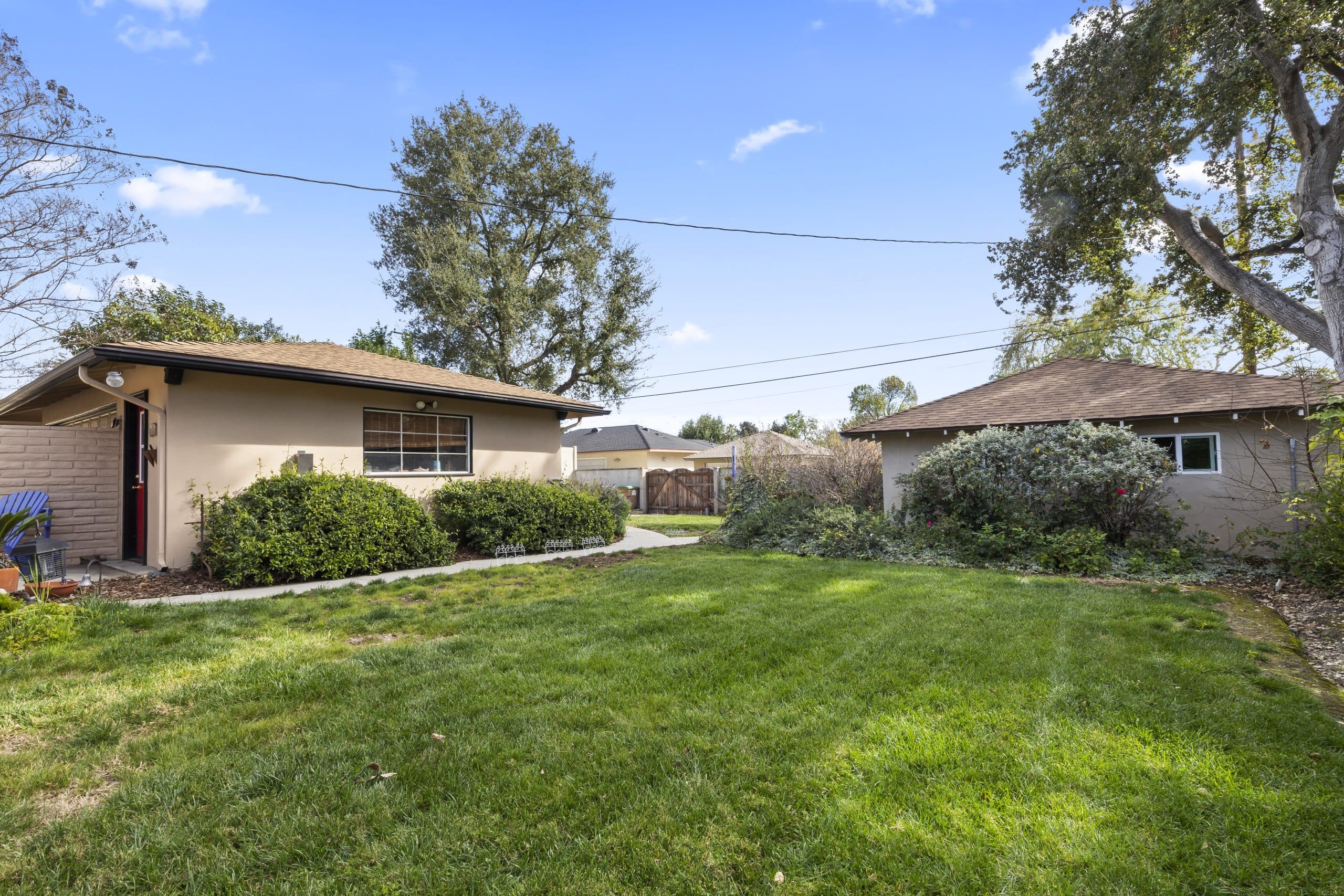 Claremont backyard with the main house and a separate additional structure across the lawn